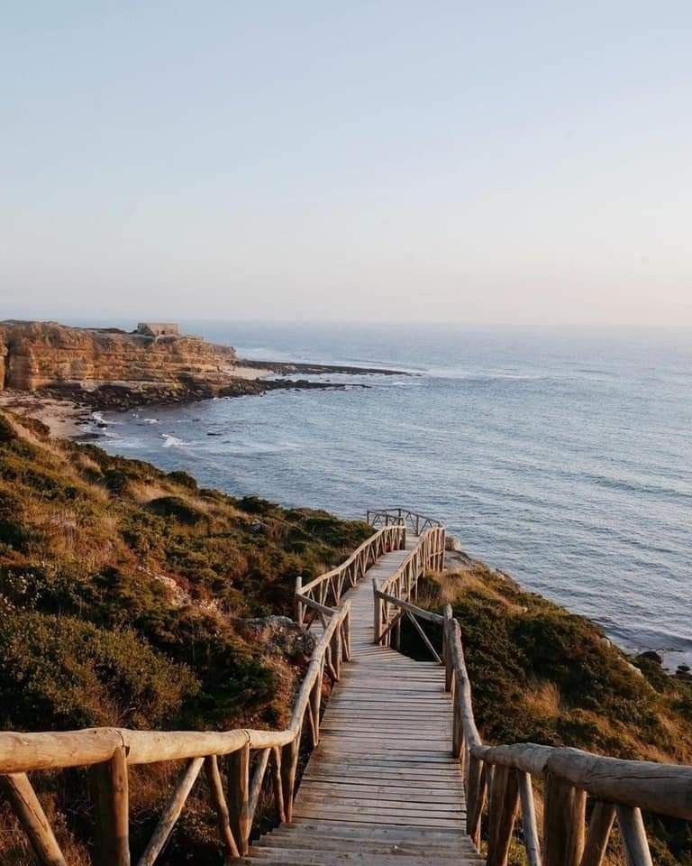 A wooden walkway down to the wild Atlantic coast at dusk, Algarve