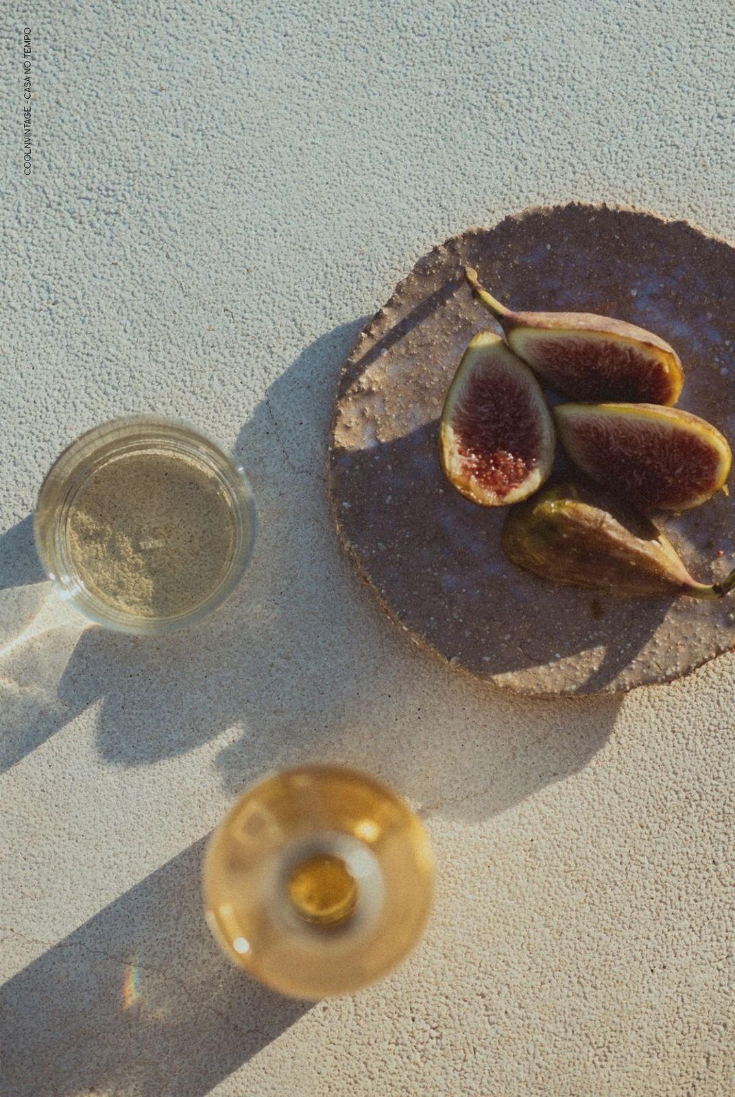 Fresh figs and chilled wine in raking afternoon light