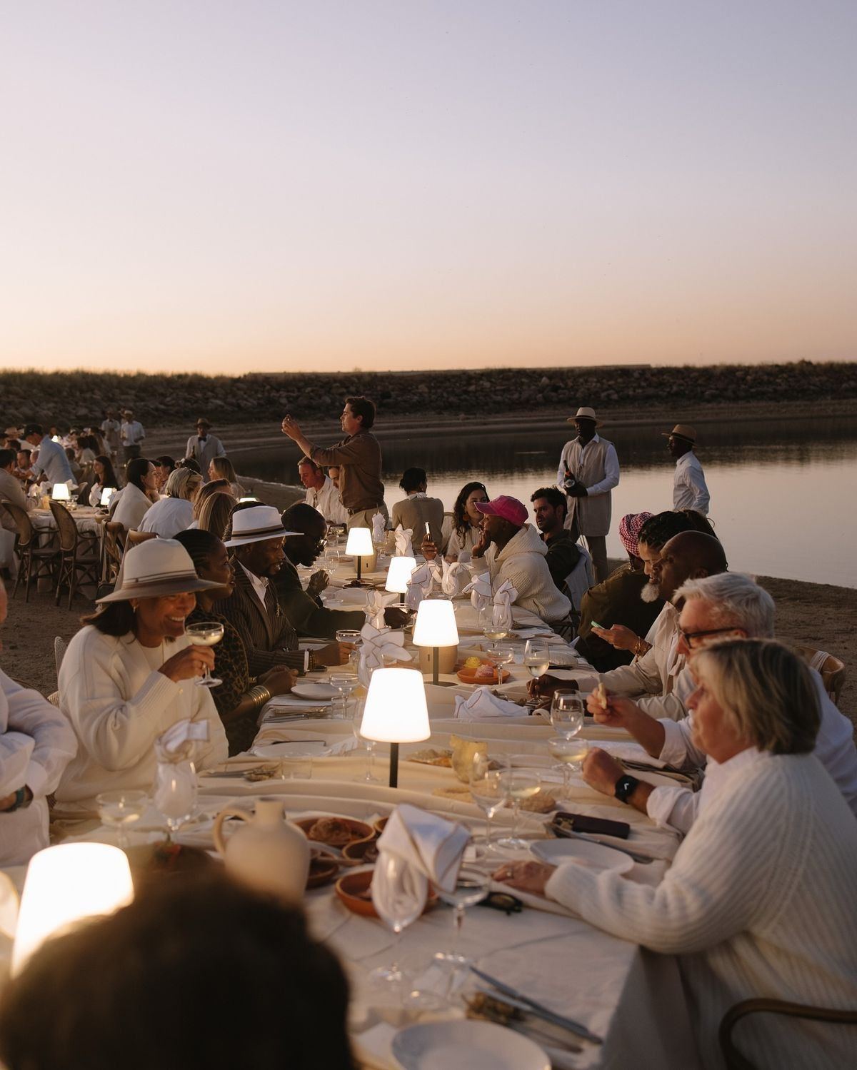 A long dinner table by the water at dusk, Comporta
