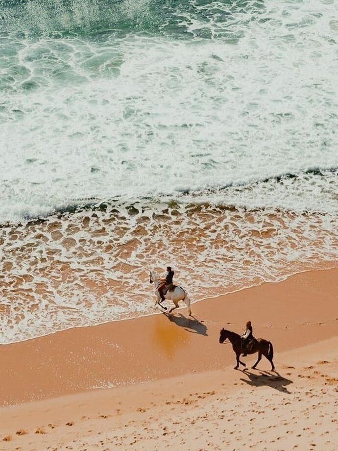 Two riders on horseback along the surf, Comporta