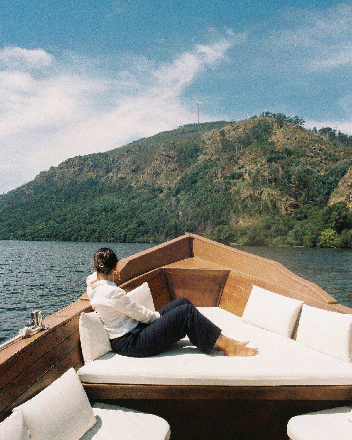 A guest reclining on a private wooden boat on the river, Douro
