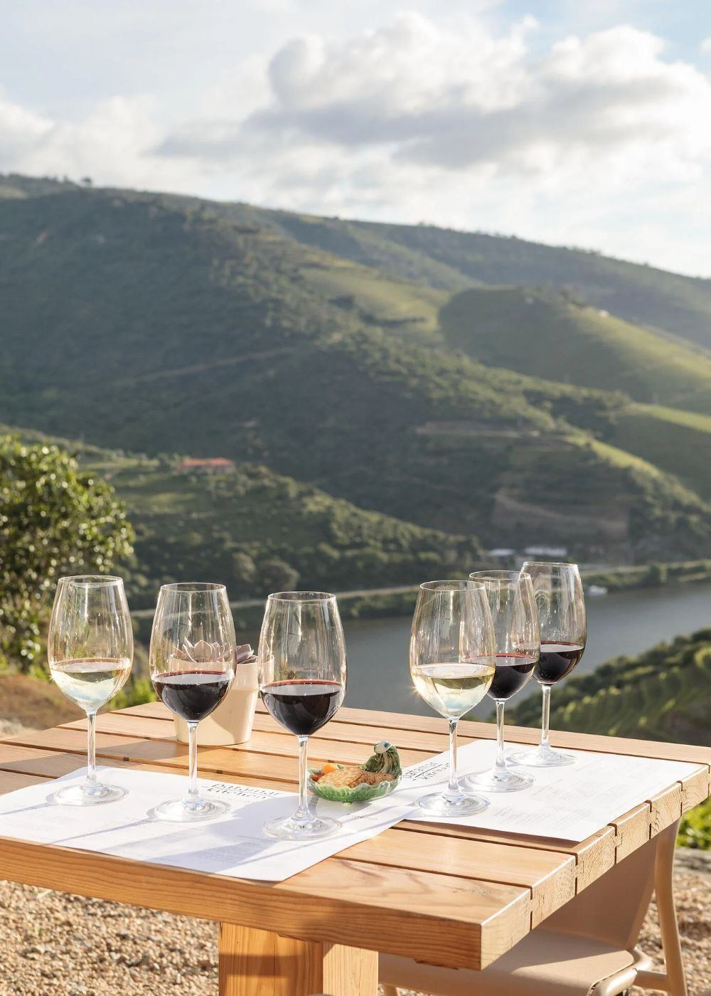 Glasses of port and wine on a table above the valley