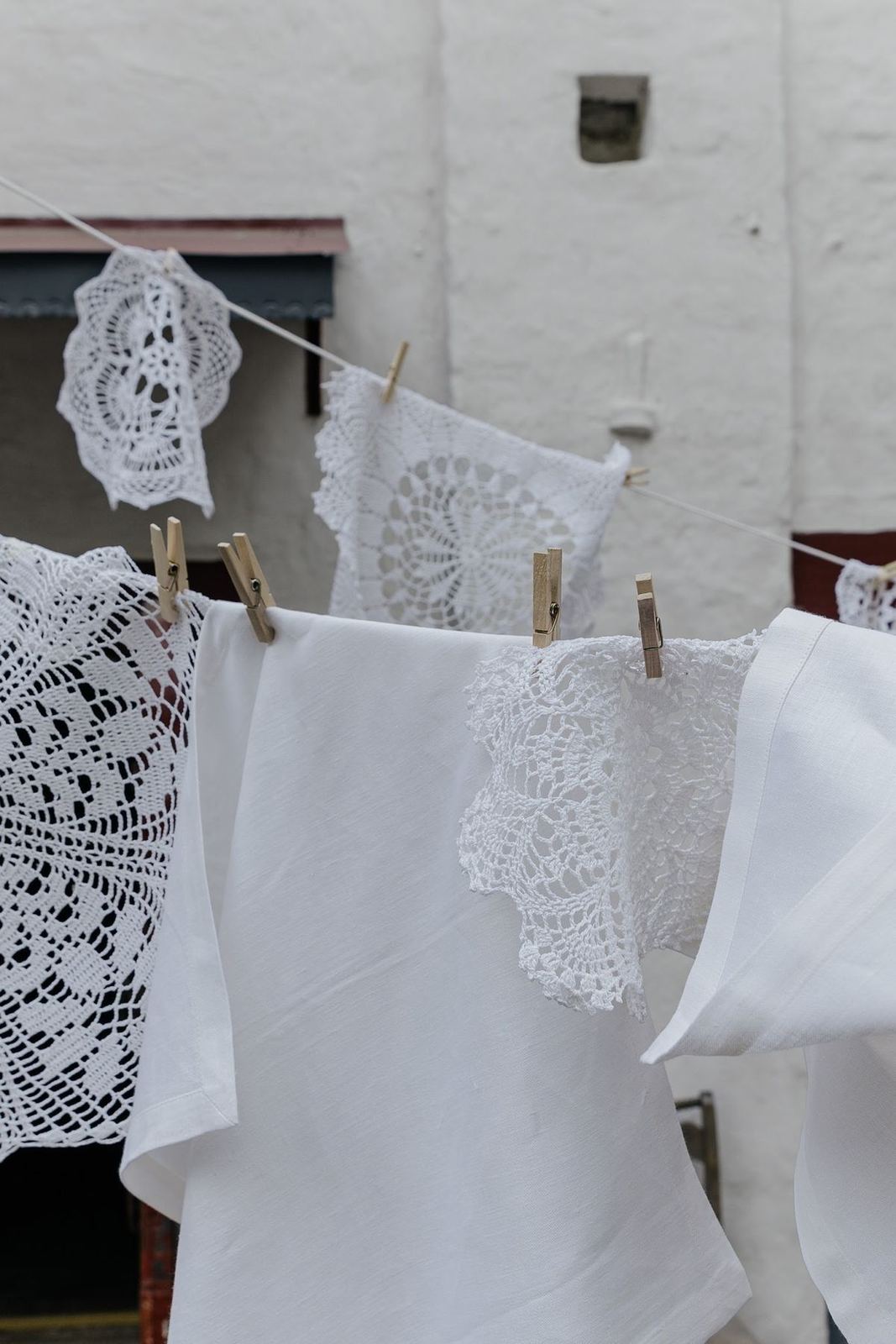 White linen and lace drying against a sunlit wall, Lisbon