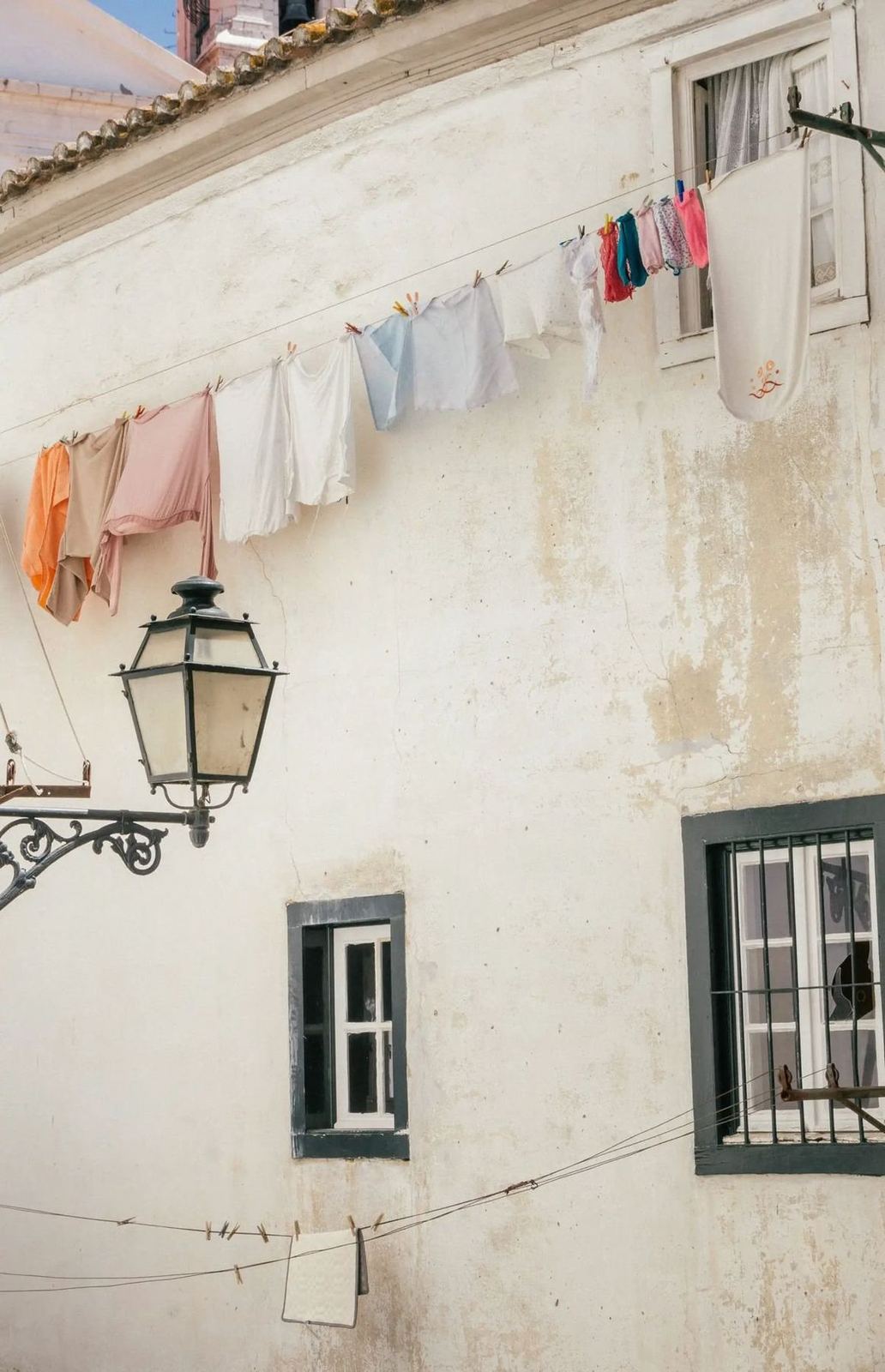 Colourful laundry strung above a street lamp in the old quarter, Lisbon