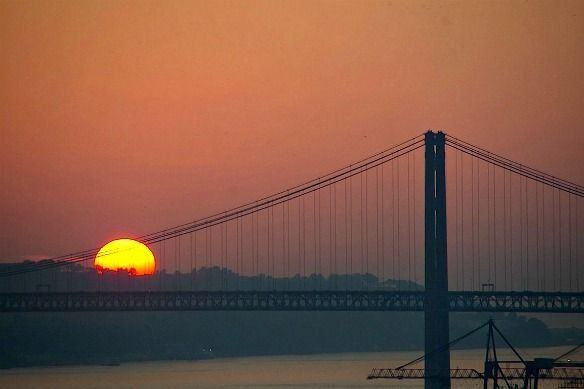 The sun setting over the Tagus beside the 25 de Abril bridge, Lisbon